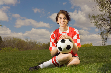 girl soccer player holding ball